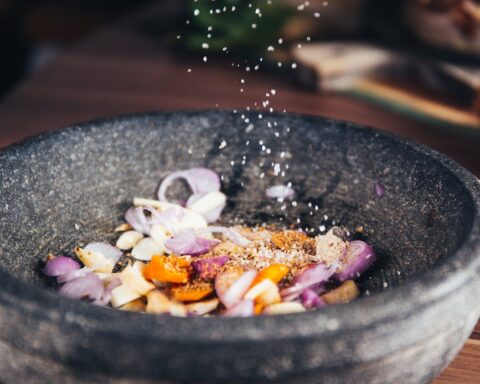 person pouring salt in bowl