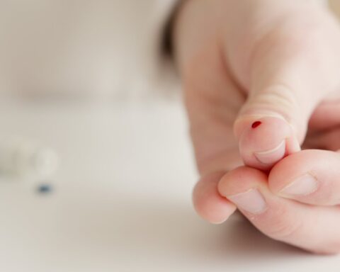 person with tiny blood on finger after a blood test