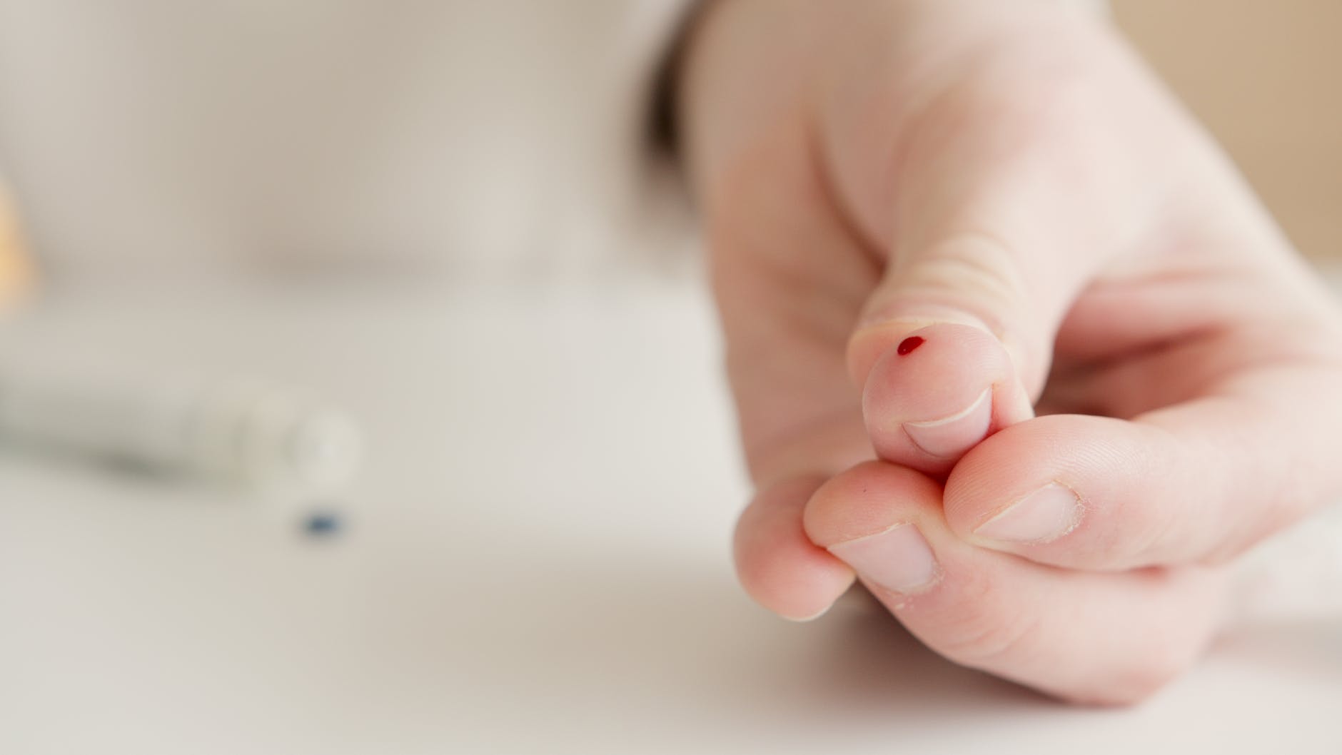 person with tiny blood on finger after a blood test